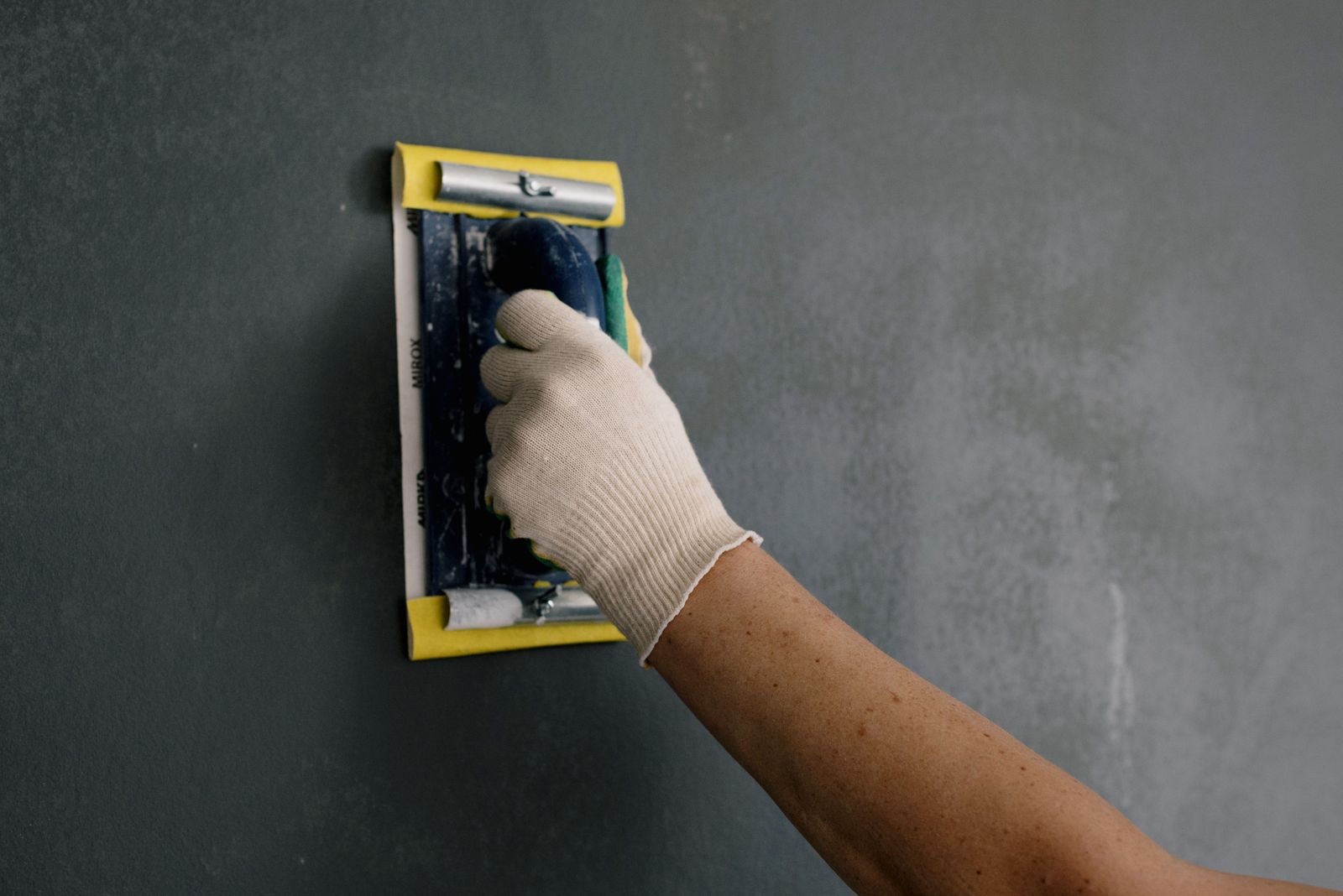 Hand smoothing a wall before decorating
