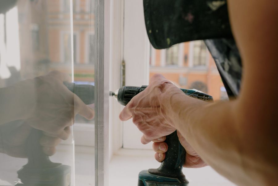 Handyman repairing a window fitting